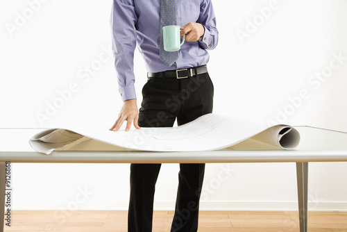 Businessman standing over plans. photo