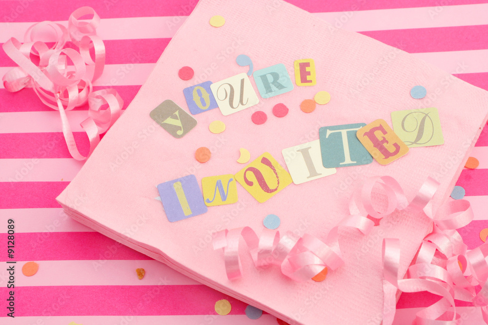 cut out letters spelling you're invited on pink napkins cut out letters spelling you're invited on pink napkins