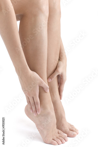 Woman rubbing her feet on white background .