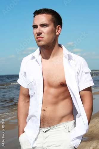 sexy young guy on the beach photo