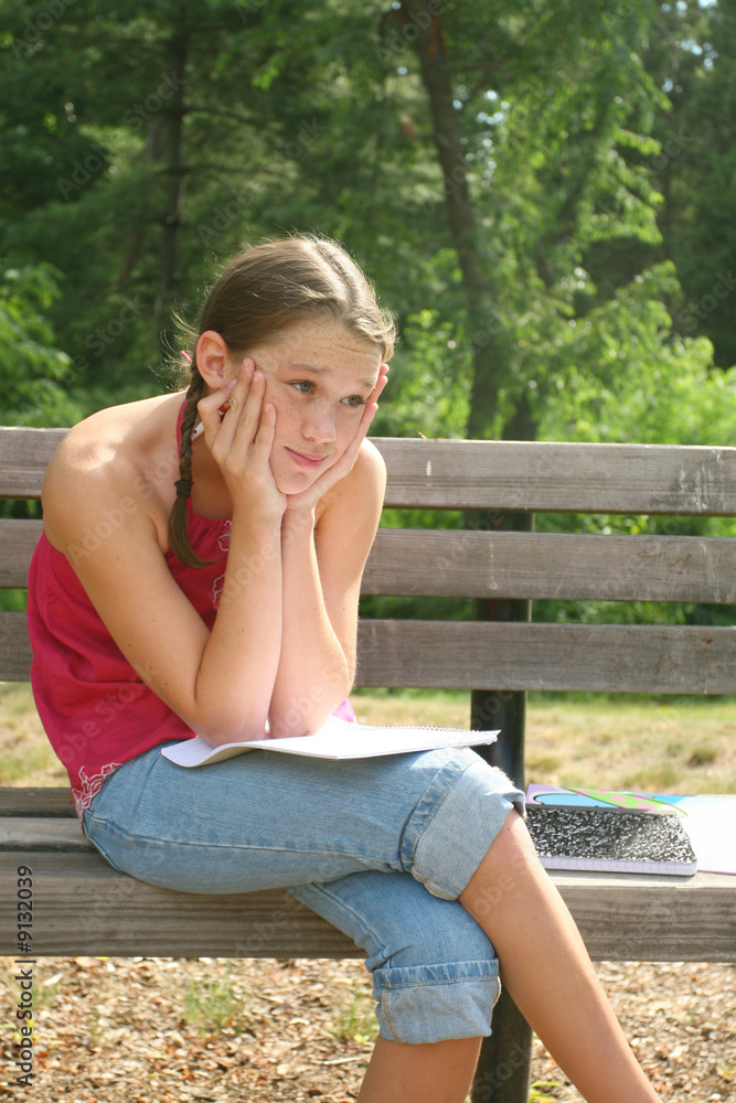 School girl thinking and working on difficult homework School girl thinking and working on difficult homework