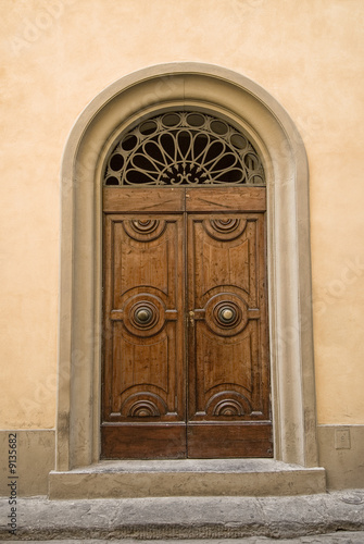 ornate wooden door, on cobble street, Florence, Italy
