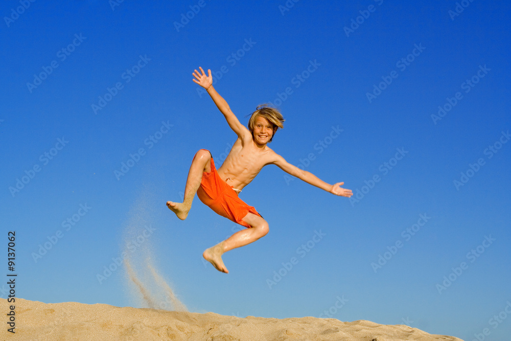 happy child jumping on beach vacation