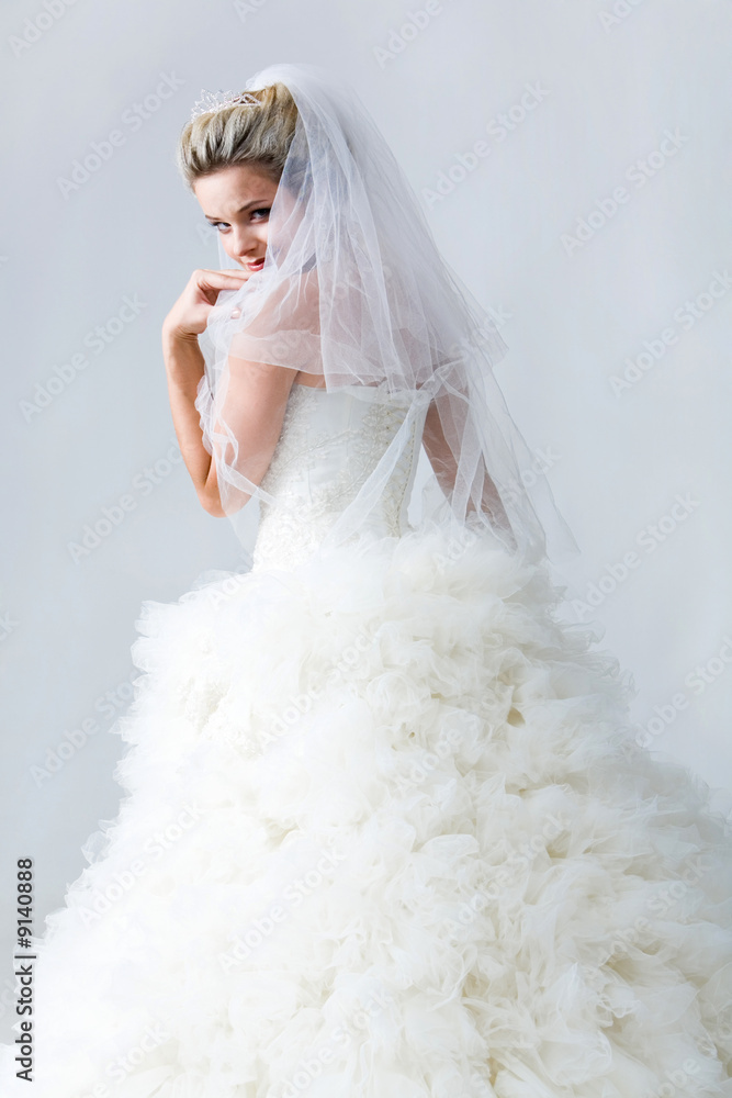 Naklejka premium Portrait of beautiful timid fiancee in white nuptial dress