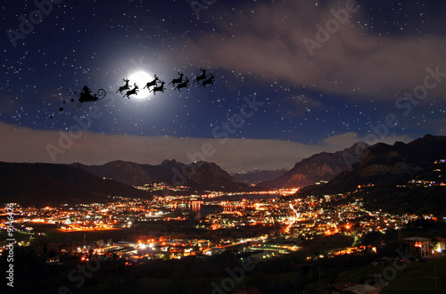 Santa Claus in the Christmas night and city landscape
