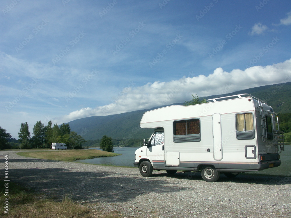 Un camping-car arrêté au bord d'une rivière en bivouac Un camping-car arrêté au bord d'une rivière en bivouac