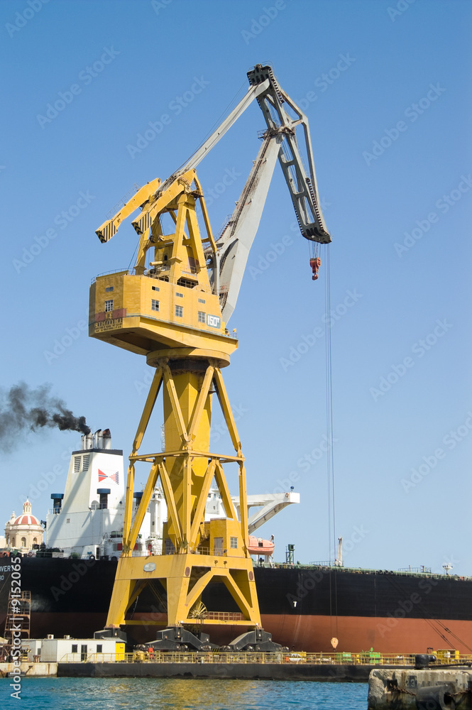 Yellow crane and ship in harbour or dry dock