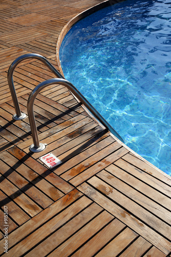 Fragment of pool with a ladder and transparent water