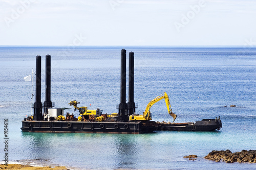 Dredger near the shore cleaning the bay