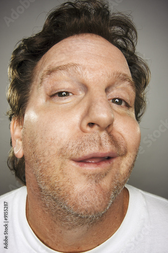 Goofy Guy with Obnoxious Expression on a Grey Background.