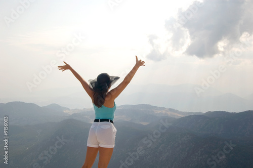 Attractive woman reaching hands to the sun