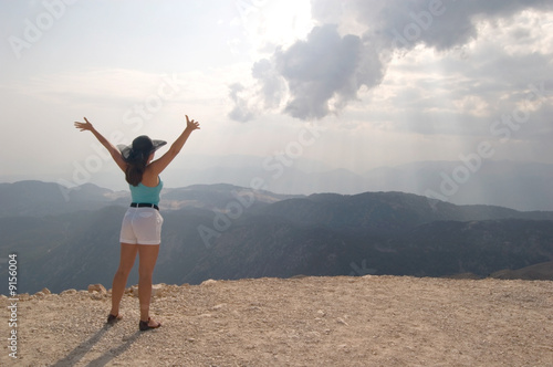 Attractive woman reaching hands to the sun