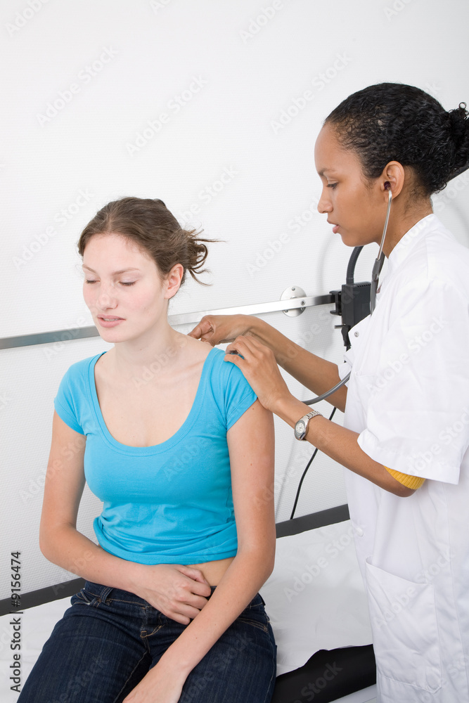 Obraz premium Doctor listening with the stethoscope to her patients breathing