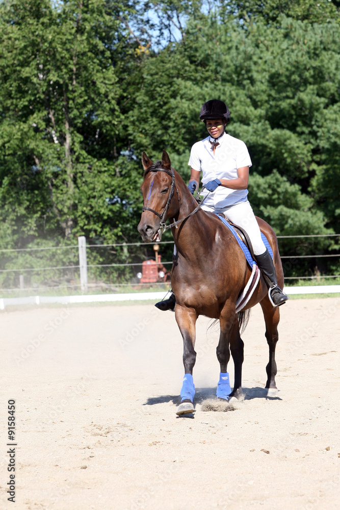 teen on horse in ring at show with dust blowing teen on horse in ring at show with dust blowing