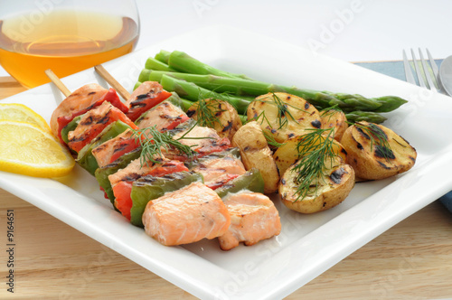 Grilled salmon with fresh vegetables on a skewer.