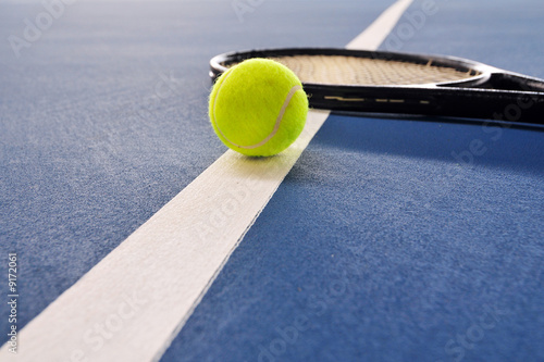 Tennis ball and racquet on the court