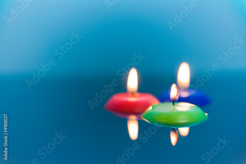 Three candles in water - red, green and blue.