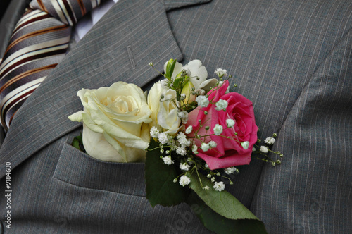 White and pink roses boutonniere on groom's wedding suit