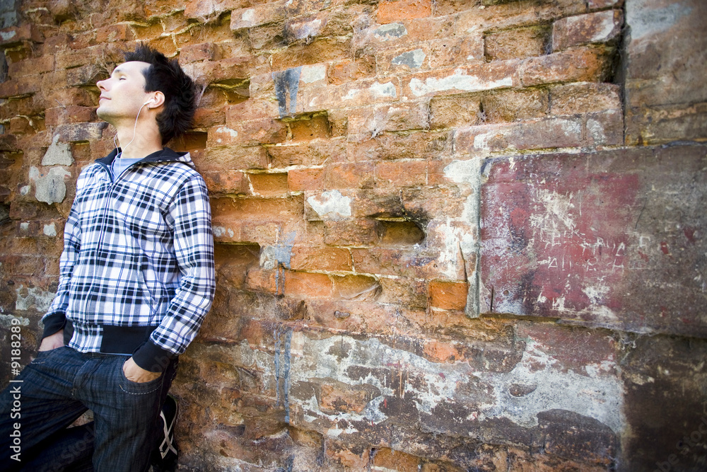 Man leaning against brick wall Man leaning against brick wall