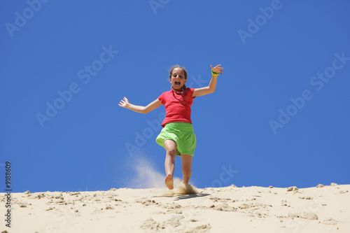 Jeune fille courant dans le sable