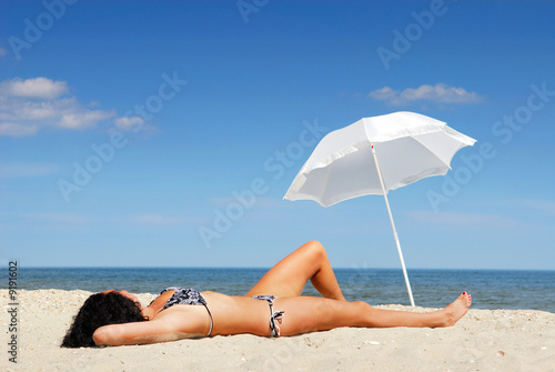 young beautiful female body lying down on the beach