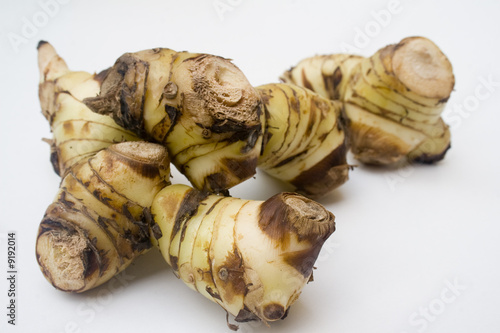 A stack of galangal root isolated against a white background photo
