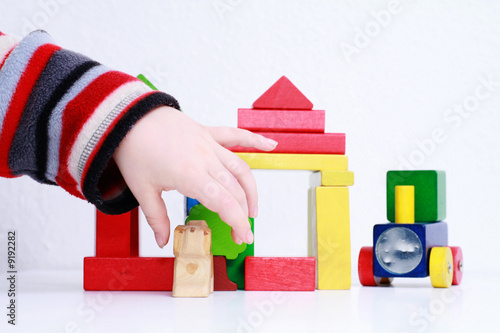 kid hands playing with wooden toys - isolated background ............