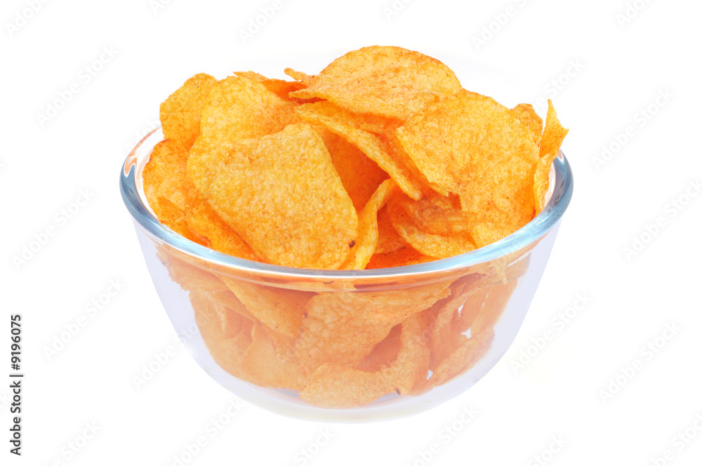 Heap of fried potato chips in glass bowl on white background.