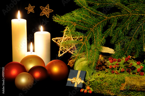 Christmas balls, burning candles, gift box and golden stars