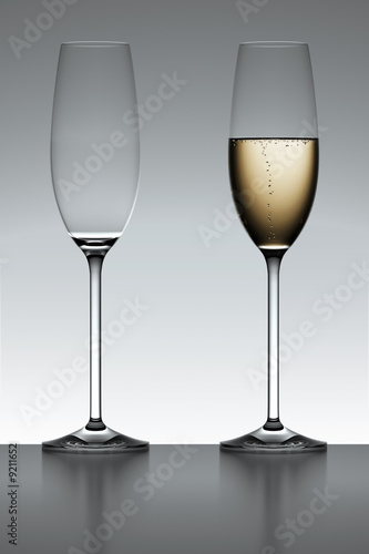 Fotografia Full and empty champagne flute iover a gray background.