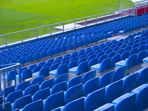 Blue chairs in a soccer stadium.