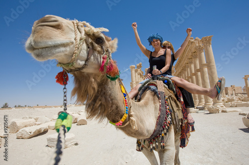 two girls are ride on camel in desert photo