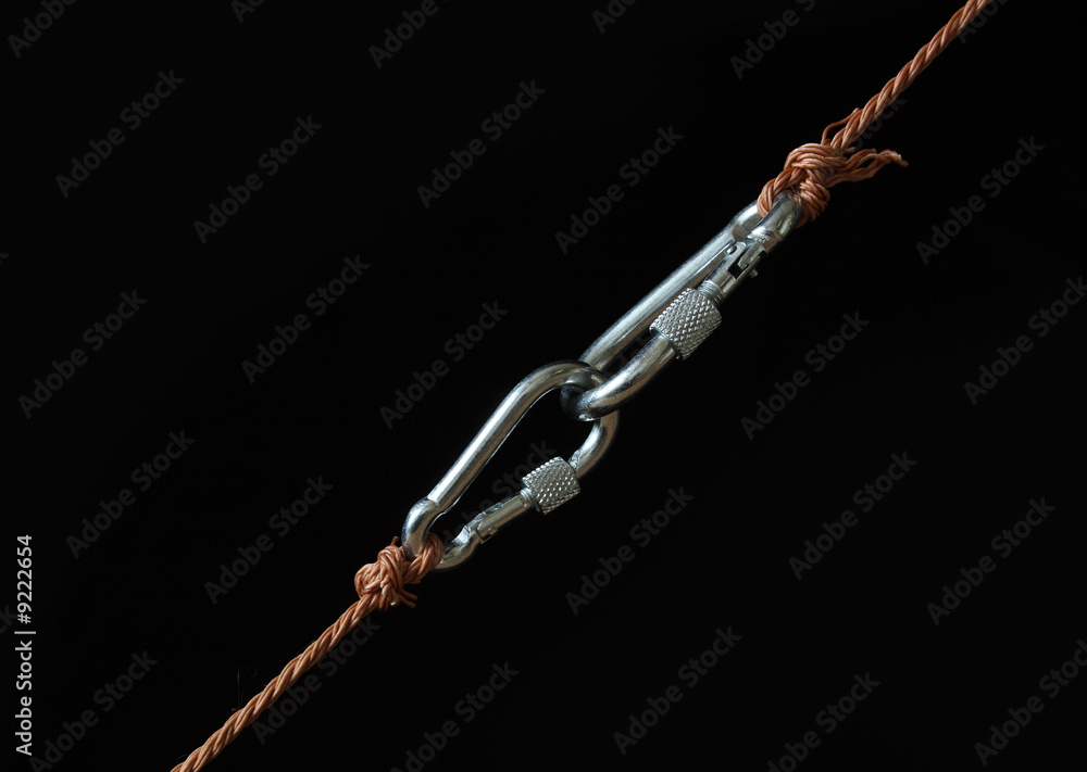Fototapeta premium Two fastened clasps hanging with rope on black background