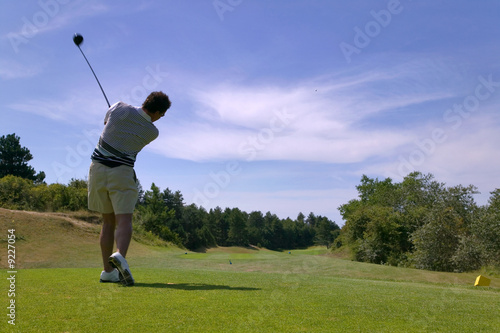 Shot of a male golfer teeing off with the ball in mid air