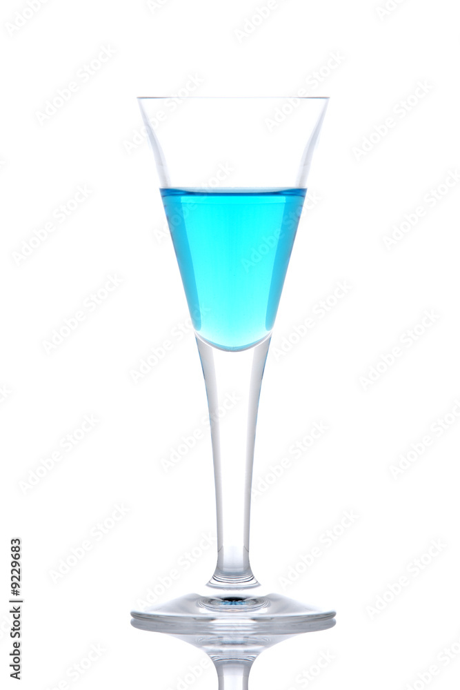 Glass of blue paradise cocktail reflected on white background Glass of blue paradise cocktail reflected on white background