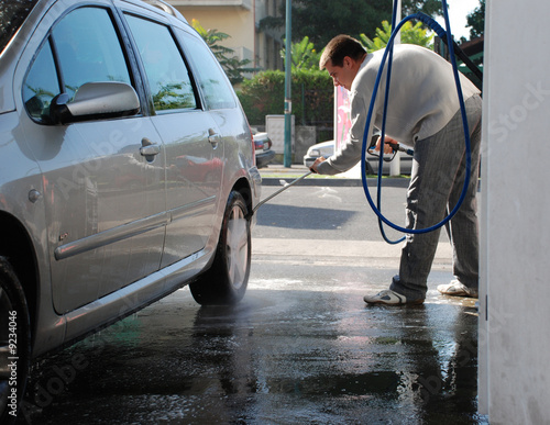 homme nettoyant une voiture grise - man washing his car photo