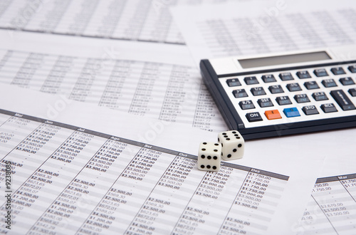 two white dice on the financial shrrt with calculator