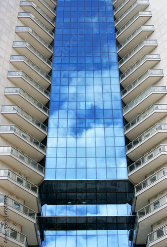 Perspective of tall modern building with sky reflection