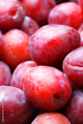 Lots red ripe plums close-up. Shallow DOF 