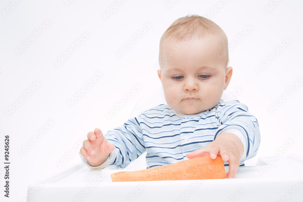 little, cute baby boy eating fresh carrot, on white little, cute baby boy eating fresh carrot, on white