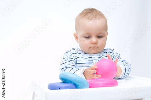 cute baby boy playing with colorful toys