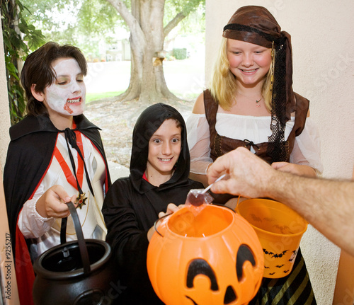 Adorable trick or treaters in the doorway waiting for candy. photo