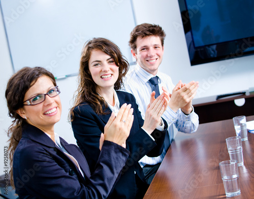 Happy businesspeople clapping on business training photo