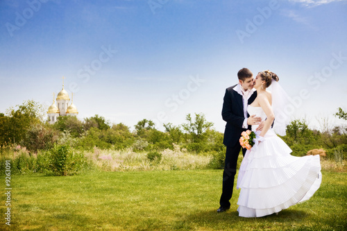 groom kisses bride near the church