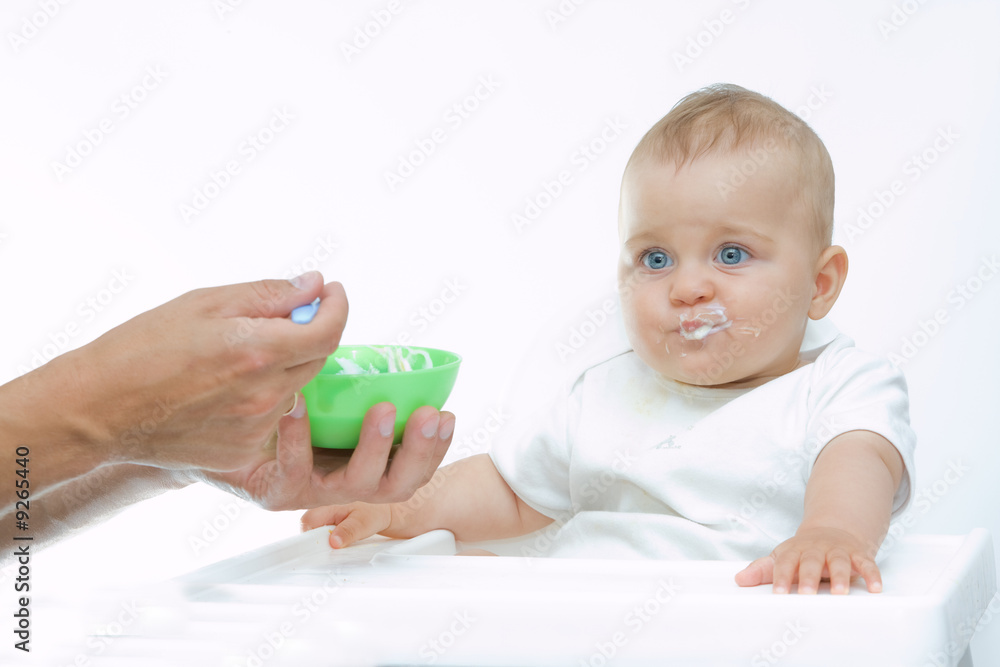 man feeding baby with a spoon, on bright background man feeding baby with a spoon, on bright background