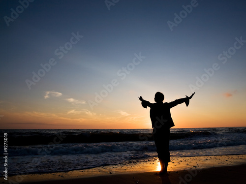 Silhouette of happiness woman at seashore on the sunset.. © Adam Gryko
