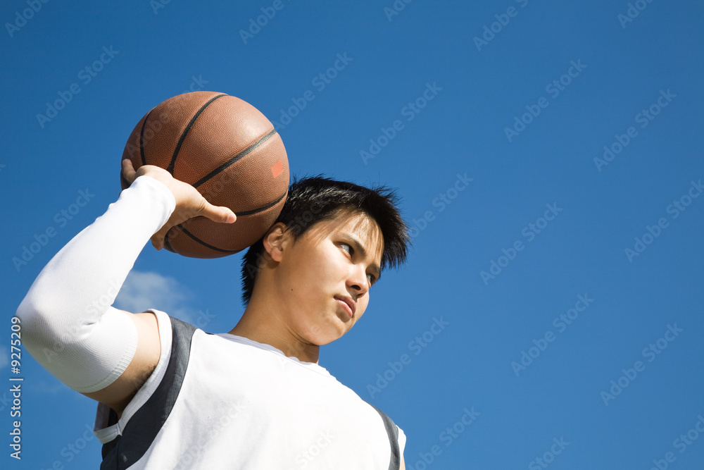 A shot of a young asian basketball player holding a basketball