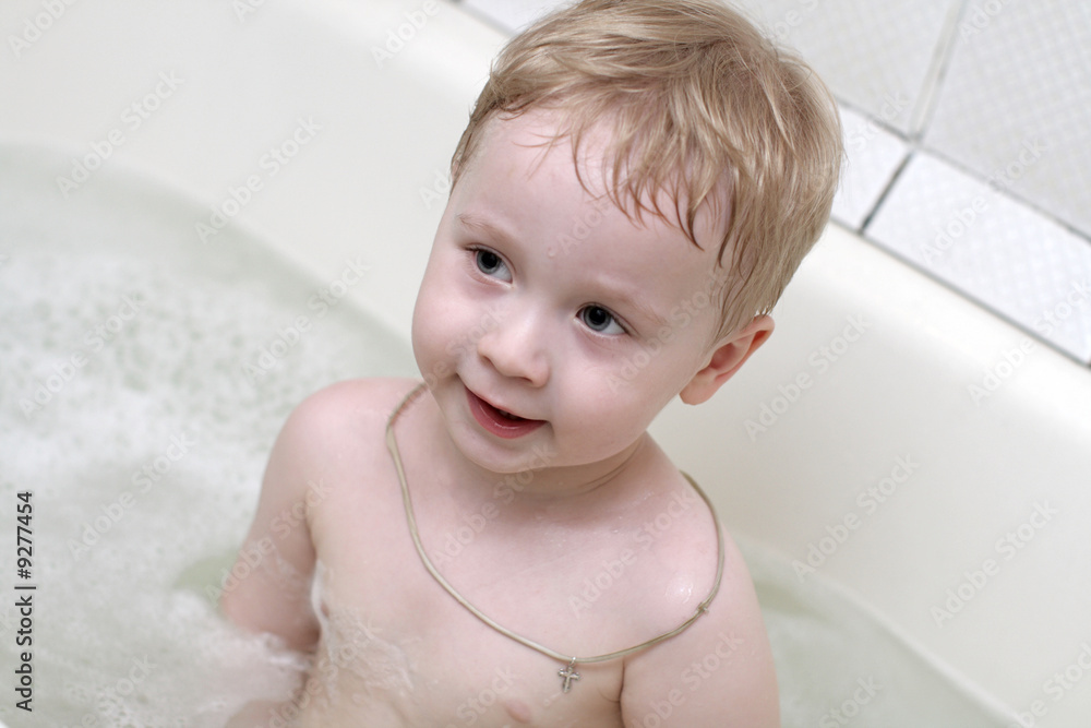 The boy takes a bath in bath-room