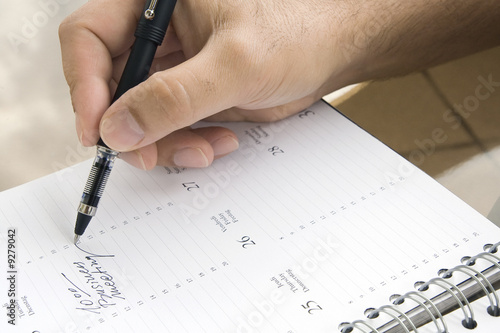Man writing down the date of business meeting
