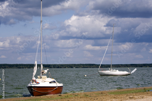 Two, small yachts at the sandy lakeside
